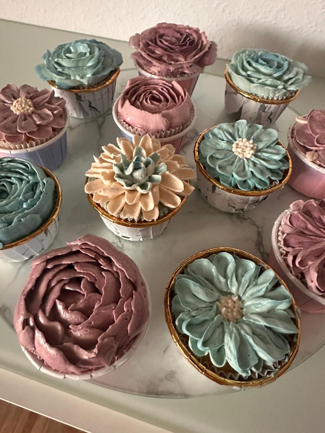 Cupcakes mit pastellfarbenen Buttercreme-Blüten