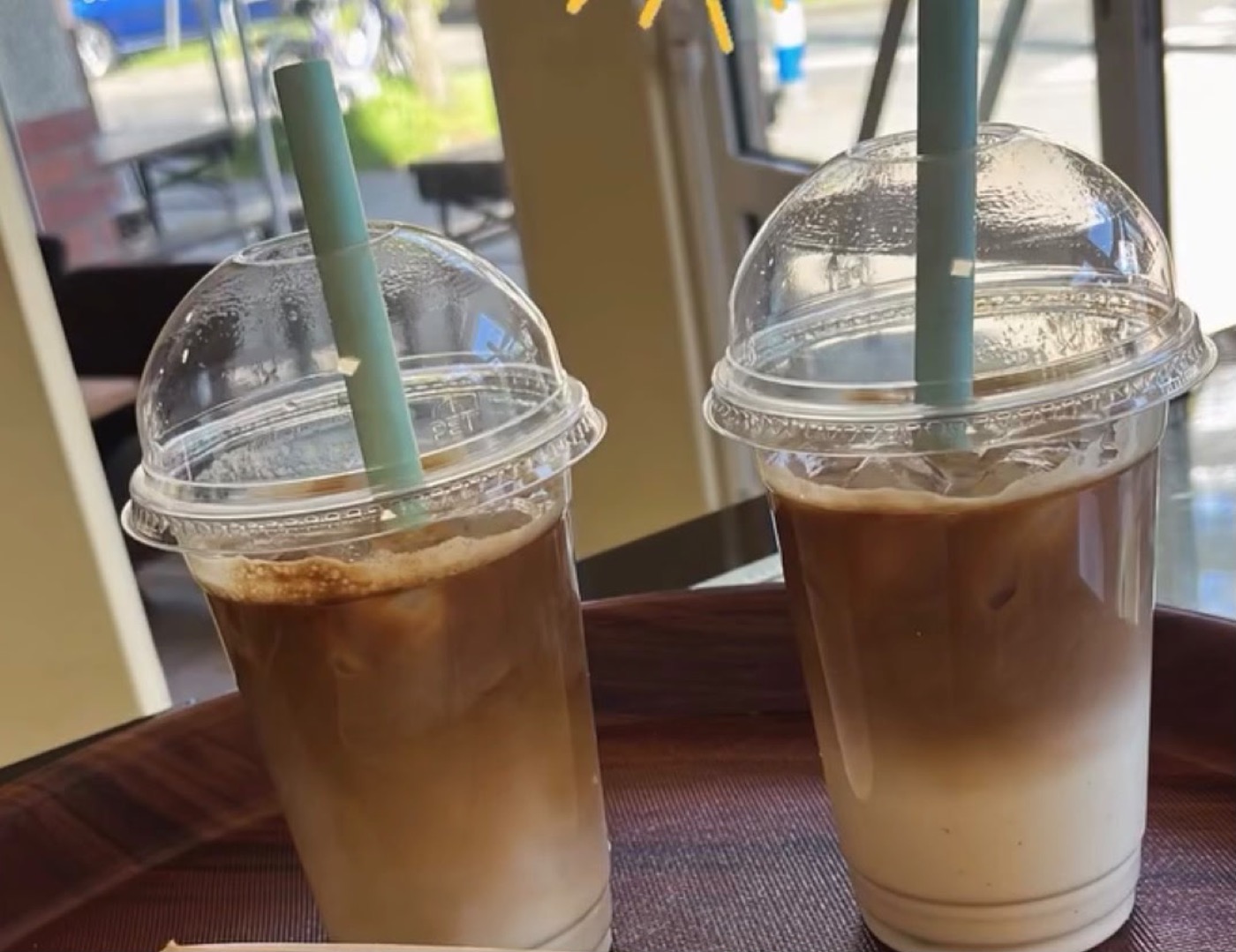 Zwei Iced Coffees mit Strohhalm auf dem Tablett
